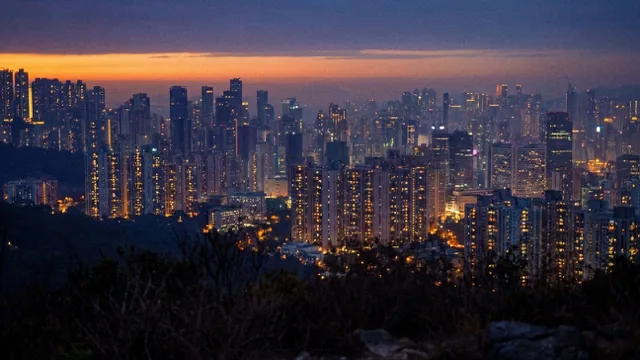 The city at night, fully lit, lights twinkling in the haze.