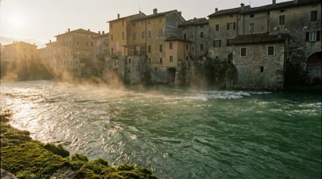 The river below the old town at dawn, mist lifting off fast green water.